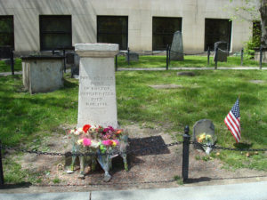 Paul Revere's stone grave marker with bouquets of flowers in the foreground