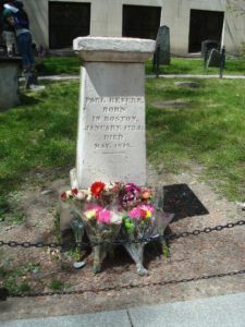 Paul Revere's grave marker with bouquets of flowers in the foreground.