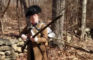 a colonial reenactor dressed as a massacussetts militiaman