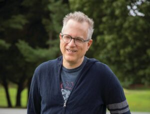 a photograph of the author Ben Mezrich leaning against a fence